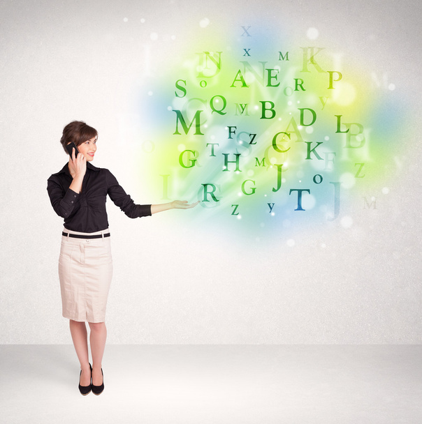 Business women with glowing letter concept - Foto, imagen