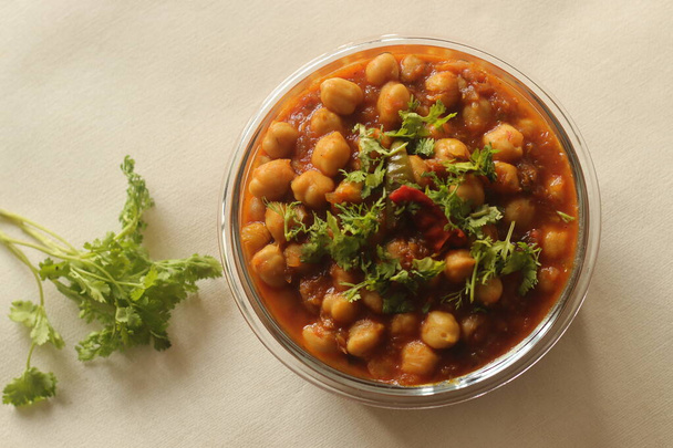 Chickpea in a thick gravy of onions tomatoes and spices. Served in a glass bowl. Shot on white background. - Photo, Image