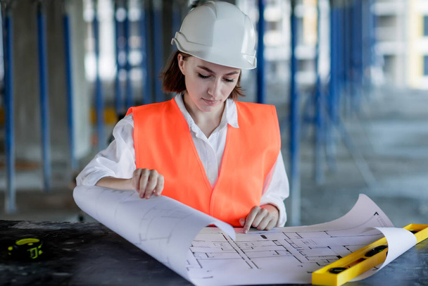 Architect or engineer working, browsing building project indoor of construction site with blueprint plan. Woman construction engineers or architects working people. - Φωτογραφία, εικόνα