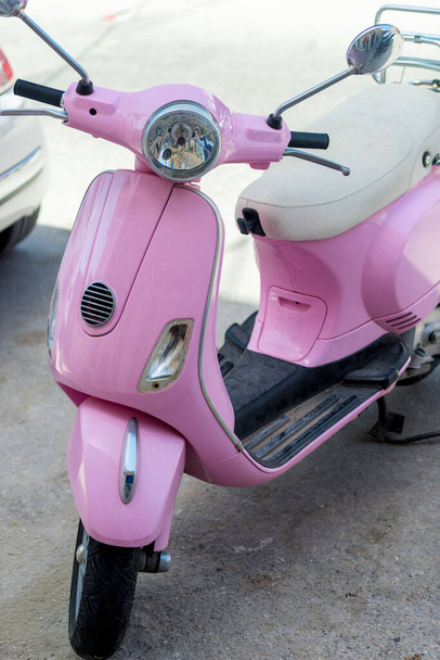 Модний вінтажний рожевий скутер у міському дворі
 - Фото, зображення