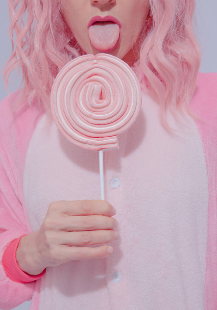 Playful Pink Pajamas Party Girl. Lollipop candy lover. Home Relax style. Kigurumi shop concept - 写真・画像