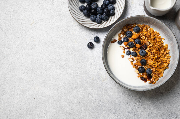 Oatmeal Granola with blueberry. Dry Breakfast. Healthy food or diet concept. Copy space. Granola with greek yogurt. Berry granola with almond. Top view. Food flatlay - Foto, Imagem