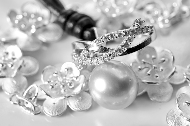 λευκό χρυσό κόσμημα με δαχτυλίδι βραχιόλι και ένα λευκό μαργαριτάρι - Φωτογραφία, εικόνα
