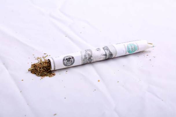 Marihuána. Füvet. Kannabisz. Pénz. Közös. Készpénz. Gördülő papírok. Pénz Rolling Papers. A marihuána profitok Bud a pénz kiváló minőségű. A marihuánát valódi pénzzel sodorta a sittre. Készpénzgördülő papírok.  - Fotó, kép