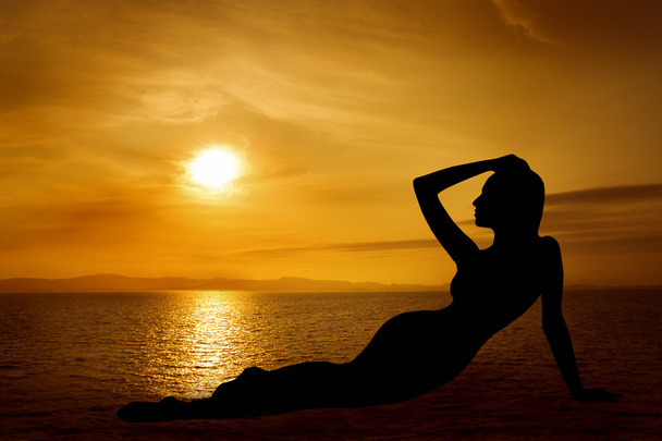 σέξι σιλουέτα γυναίκα πάνω από τον ουρανό ηλιοβασίλεμα στη θάλασσα - Φωτογραφία, εικόνα