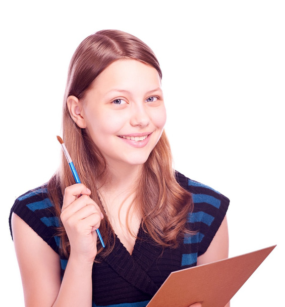 Teen girl holding paintbrush and paper - Photo, image