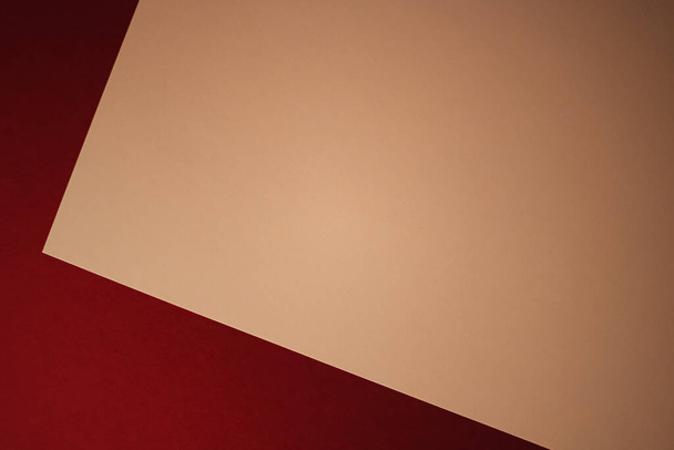 Пустая бумага формата А4, бежевый цвет на темно-красном фоне в виде офисных канцелярских принадлежностей, роскошный дизайн бренда и дизайн фирменного стиля для макета - Фото, изображение
