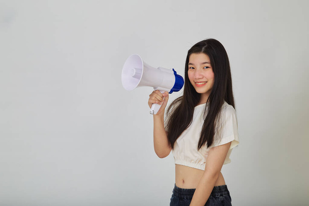 Portrait beautiful young asian woman smile with megaphone making announcement in isolated studio - Foto, imagen