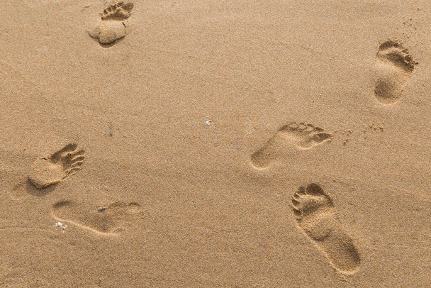 empreintes de pas des amoureux dans le sable sur le fond de la plage - Photo, image