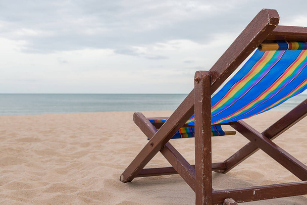 Καρέκλα παραλίας στην άμμο με φόντο τη θάλασσα και τον ουρανό - Φωτογραφία, εικόνα