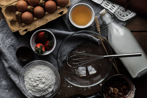 A top view of flour, eggs, and strawberries on the table for baking - Foto, immagini