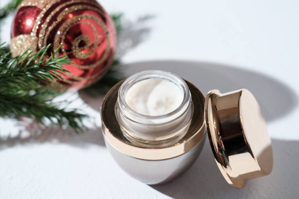 face cream in festive luxury jar next to christmas decor, new year sale or holiday present for women. face and skin care, age defying cosmetic product - Photo, Image