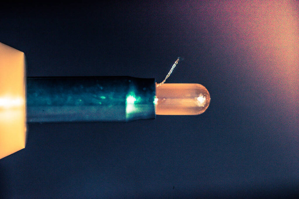 A macro shot of a small unlightened orange lightbulb - Foto, imagen