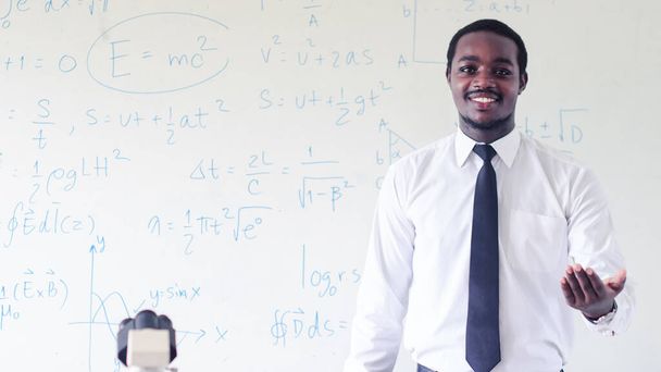 Professor cientista africano está dando aulas de ciências com o uso de microscópio na sala de aula.Conceito de Feliz Dia do Professor - Foto, Imagem