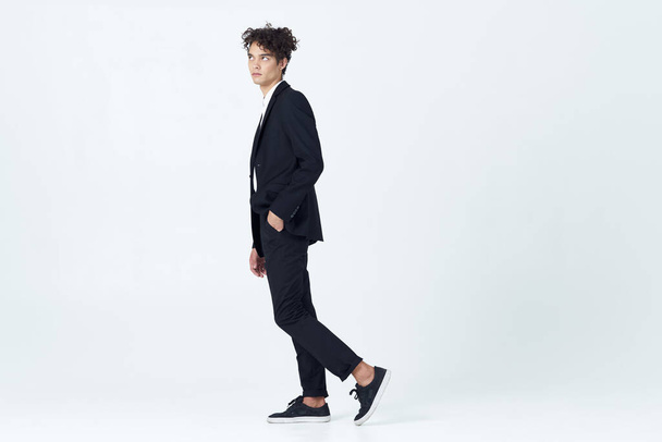 business man with curly hair in suit black blazer studio - Foto, afbeelding
