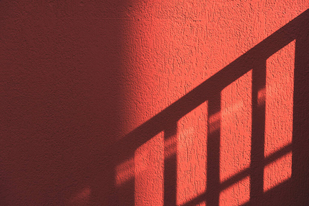 A shadow of stairs on a red textured - Fotó, kép