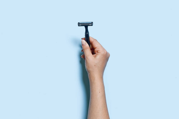 Hand holds a multiple use shaving razor - Photo, Image