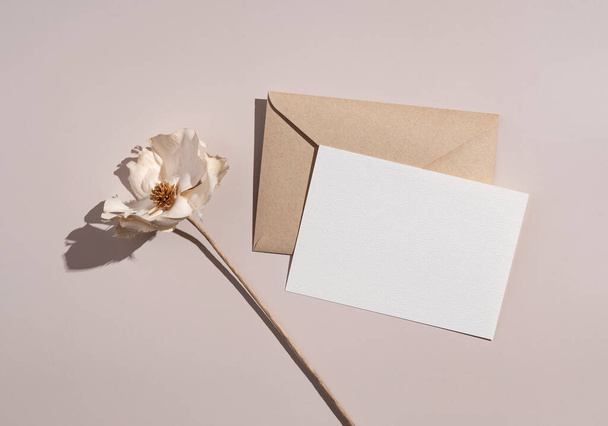 Zomer bruiloft briefpapier mockup. Stevige kleuren wenskaarten en uitnodigingen op beige achtergrond. Witte bloemen. Natuurlijk licht en schaduw. Vlakke lay, bovenaanzicht. - Foto, afbeelding