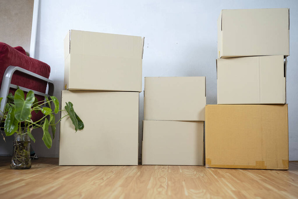 Cardboard boxes - moving to a new house. Moving boxes with belongings in empty room - Fotografie, Obrázek