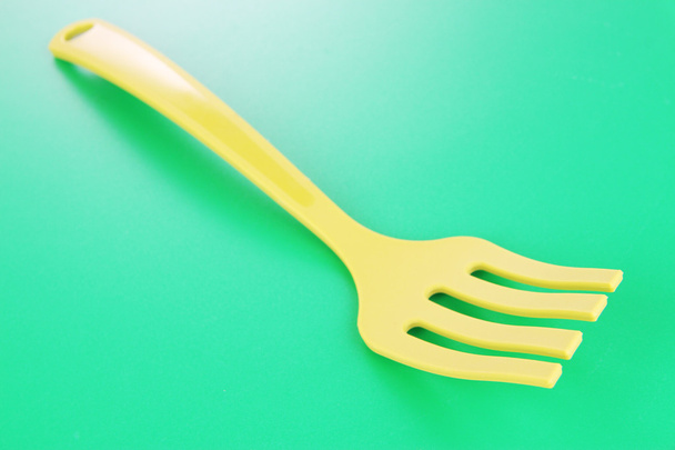 Plastic kitchen utensils on green background - Foto, afbeelding