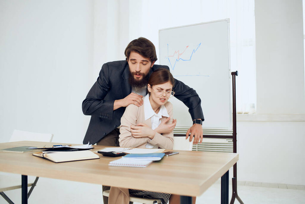 egy férfi zaklat egy nőt a munkahelyén zaklatás irodai kollégák - Fotó, kép