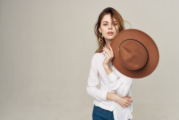 cheerful red-haired woman with hat in hand white shirt fashion decoration posing - Photo, Image