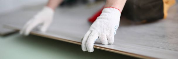 Gloved technician lays down laminate on backing - Photo, Image