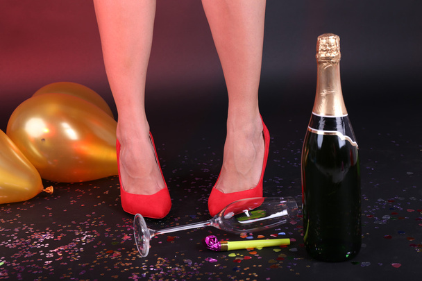 Legs with confetti, champagne and balloons on the floor - Photo, image