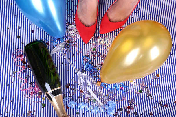 Legs with confetti, champagne and balloons on the floor - Fotó, kép