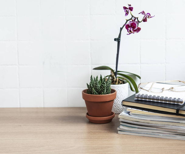 Mesa de escritorio con cuadernos, suministros y plantas de interior - Foto, Imagen