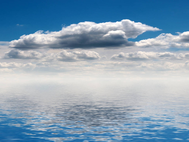 reflection of a cloudy sky in the surface of a calm ocean - Fotoğraf, Görsel