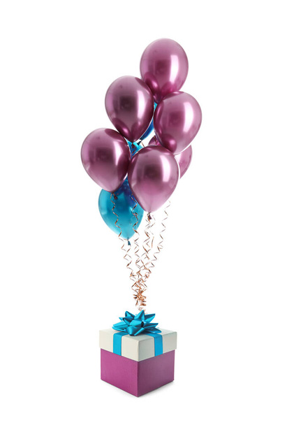 Bunch of color balloons and beautiful gift box with bow on white background - Fotoğraf, Görsel