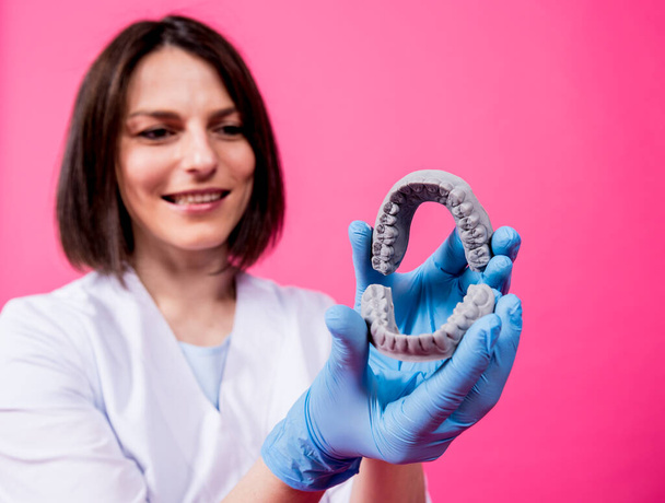 Woman dentist holds in hands dental gypsum models - Foto, Imagem
