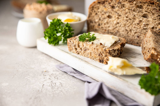 Freshly baked artisan multigrain bread with butter and pate. Breakfast with coffee, sliced bread, butter and liver pate. Light grey stone background. - 写真・画像