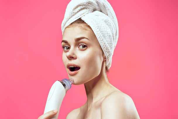 woman with towel on head naked shoulders facial massage - Foto, afbeelding