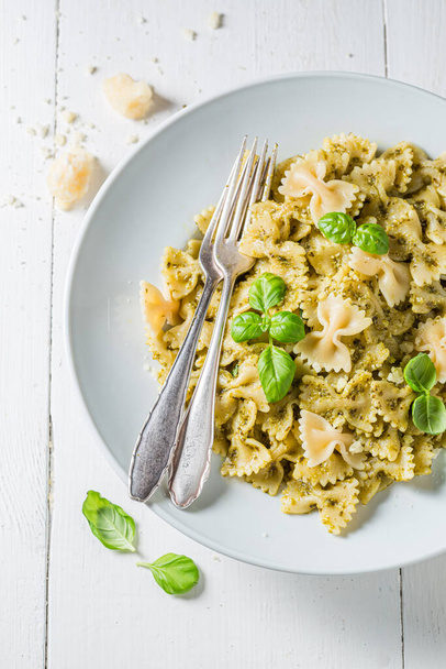 Farfalle pasta with green pesto and basil. Italian cuisine.  - Фото, изображение