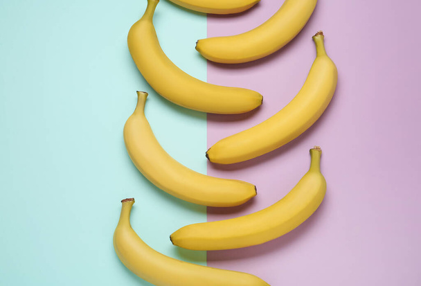 Ripe yellow bananas on color background, flat lay - Foto, imagen