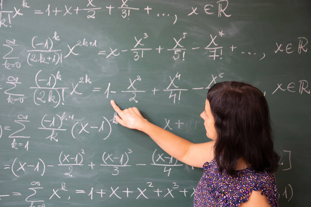 Teacher or student explaning on blackboard during math lesson in school classroom. - Fotó, kép