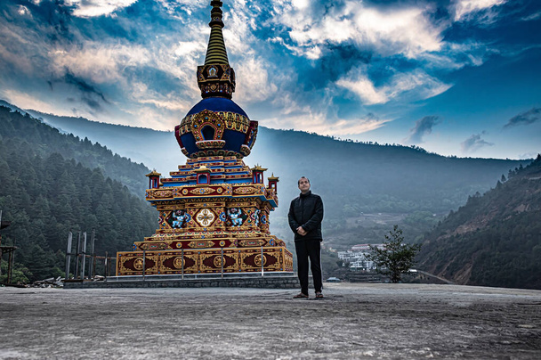 Sabahleyin Budist stupa 'nın yanında düz açıyla parlak mavi gökyüzü olan adam Dirang Manastırı Arunachal Pradesh Hindistan' da çekilmiştir.. - Fotoğraf, Görsel