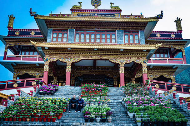 Młoda para siedzi na schodach buddyjskiego klasztoru w godzinach porannych z niskiego kąta obraz jest robiony w dirang klasztor arunachal pradesh Indii. - Zdjęcie, obraz