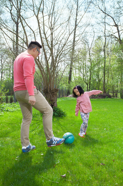 Asian family playing football - Foto, afbeelding