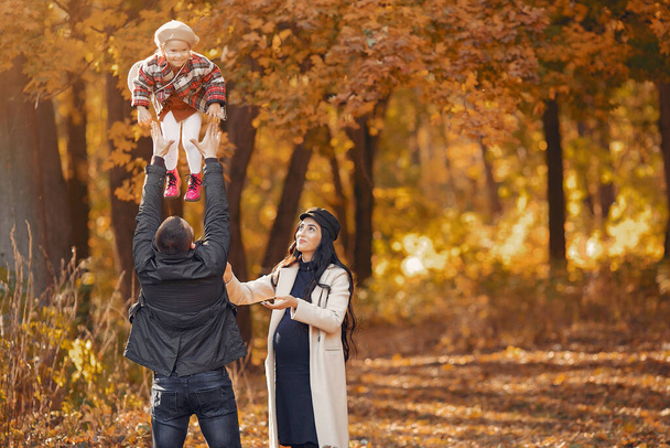 Family with little daughter in a autumn park - Fotó, kép