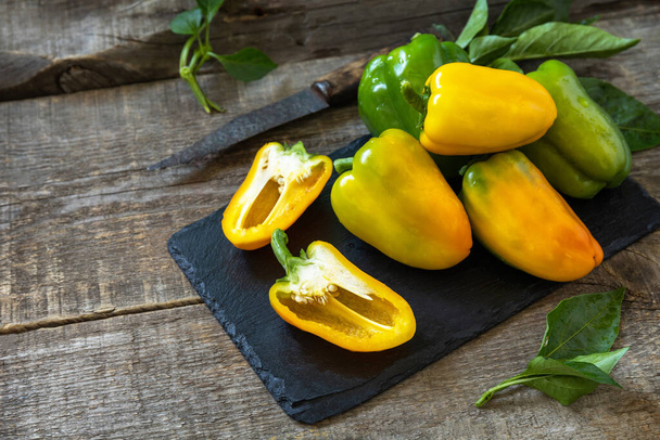 Organic healthy raw ripe sweet pepper, yellow paprika, on a kitchen wooden table. The concept of Diet menu and harvesting. - 写真・画像