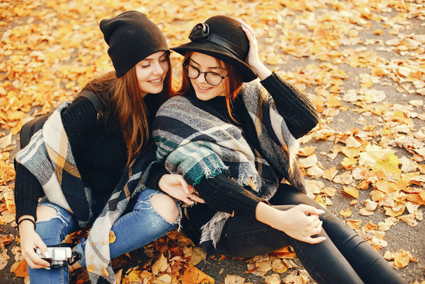 two young girls walk around the city in the autumn city and park - Photo, image
