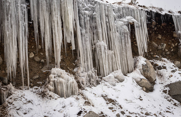frozen icicles sticking at mountain peak at winter in morning - Photo, Image