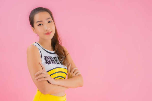 Porträt schöne junge asiatische Frau Cheerleader auf rosa isolierten Hintergrund - Foto, Bild