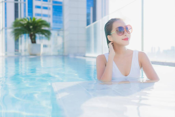 Güzel bir Asyalı kadının portresi tatil gezilerinde yüzme havuzunda rahatlar. - Fotoğraf, Görsel