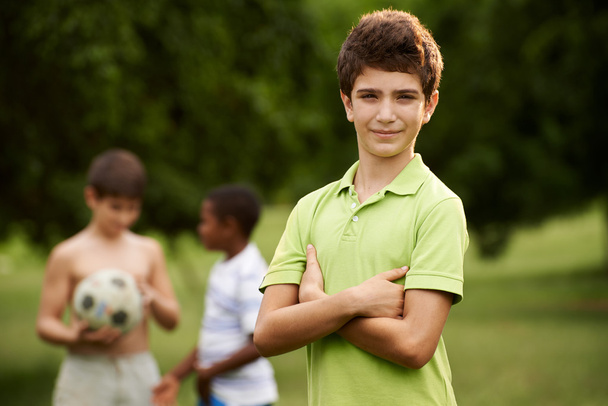 portrét chlapce a přáteli, kteří hrají fotbal v parku  - Fotografie, Obrázek