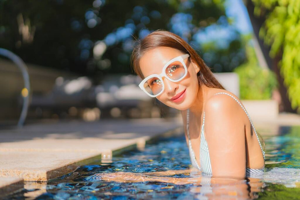 Güzel Asyalı kadın gülümsemesi. Tatil için yüzme havuzunda rahatla. - Fotoğraf, Görsel