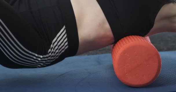Γυναίκα στο γυμναστήριο κάνει ένα μυοσκελετικό μασάζ της πλάτης και ωμοπλάτες με τη βοήθεια ενός κυλίνδρου. Γυμναστήριο εκπαιδευτής ασχολείται με τη φυσιοθεραπεία με ένα ρολό αφρού - Πλάνα, βίντεο